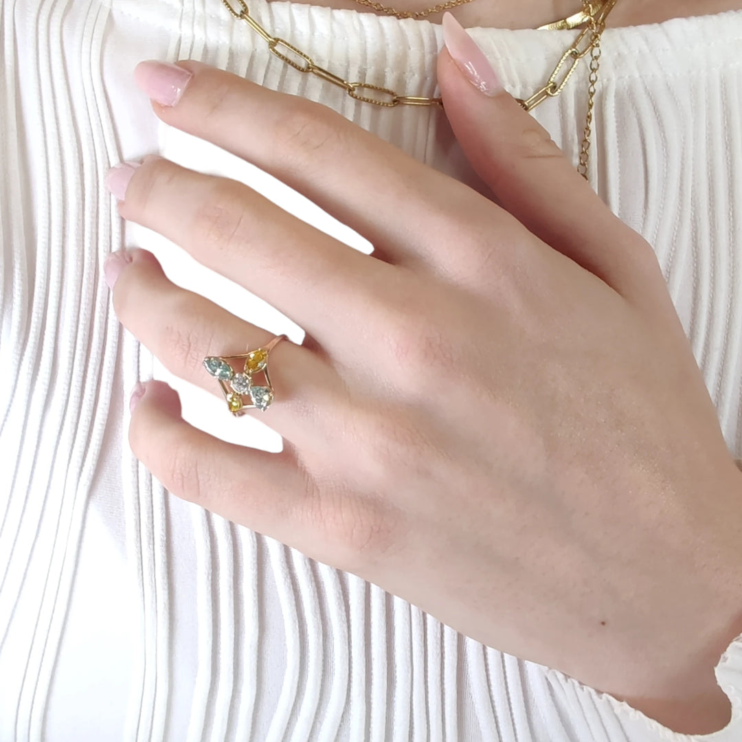 Second pose of a model's hand displaying a 14K yellow gold engagement ring with a mix of incolor and fancy colored diamonds, emphasizing its elegance and unique appeal