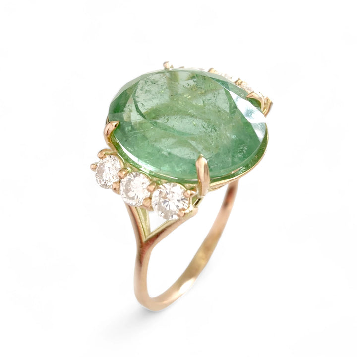 Side vertical view of a 14K yellow gold engagement ring featuring a central oval green tourmaline and three diamonds on each side, perfect for a contemporary, handmade gift