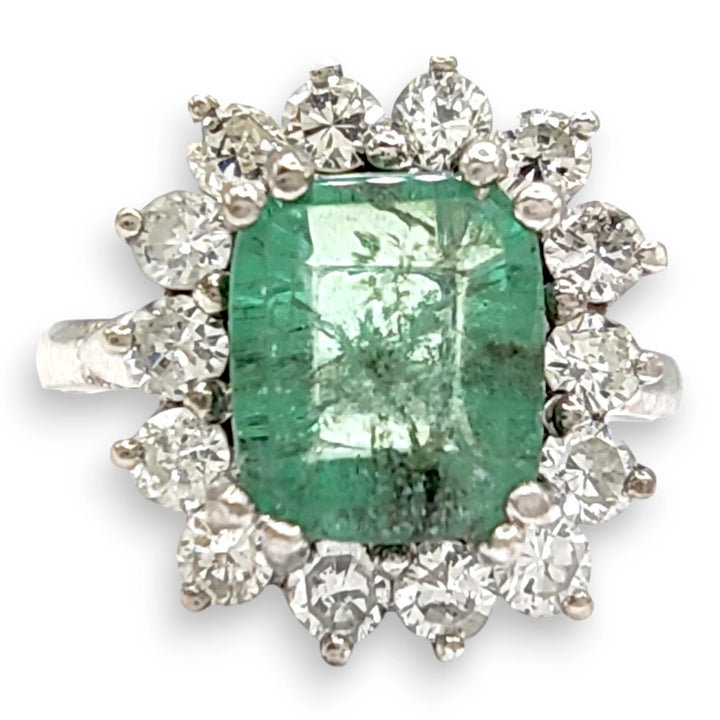 A luxurious 18K white gold engagement ring featuring a central emerald surrounded by a halo of diamonds, perfect as an exquisite Christmas gift or for a romantic proposal.