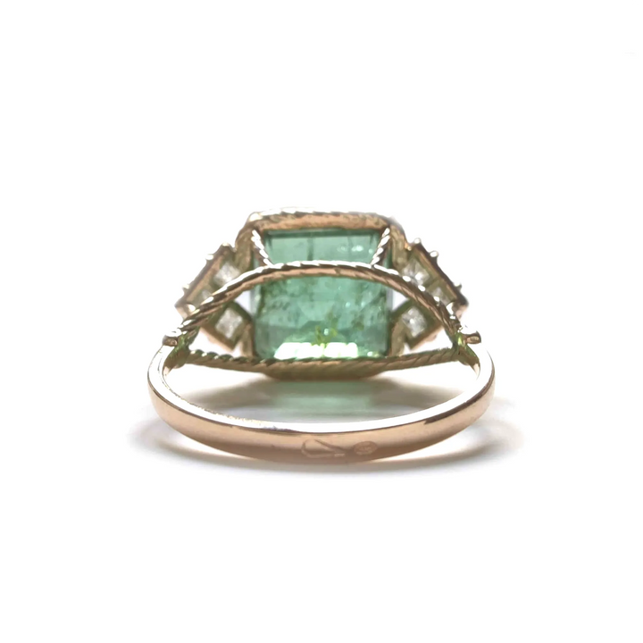 Back view of a 14K yellow gold engagement ring showing a green tourmaline and princess-cut diamonds, highlighting the elegant and detailed craftsmanship of the vintage-style setting