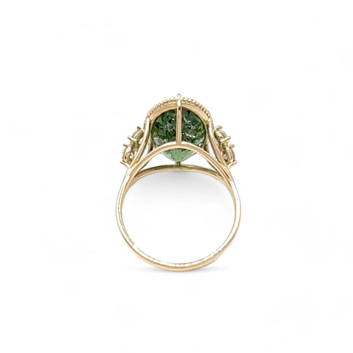 Back view of a 14K yellow gold cocktail ring with an oval green tourmaline and diamonds, highlighting the ring's certified gems and fine miligrain work