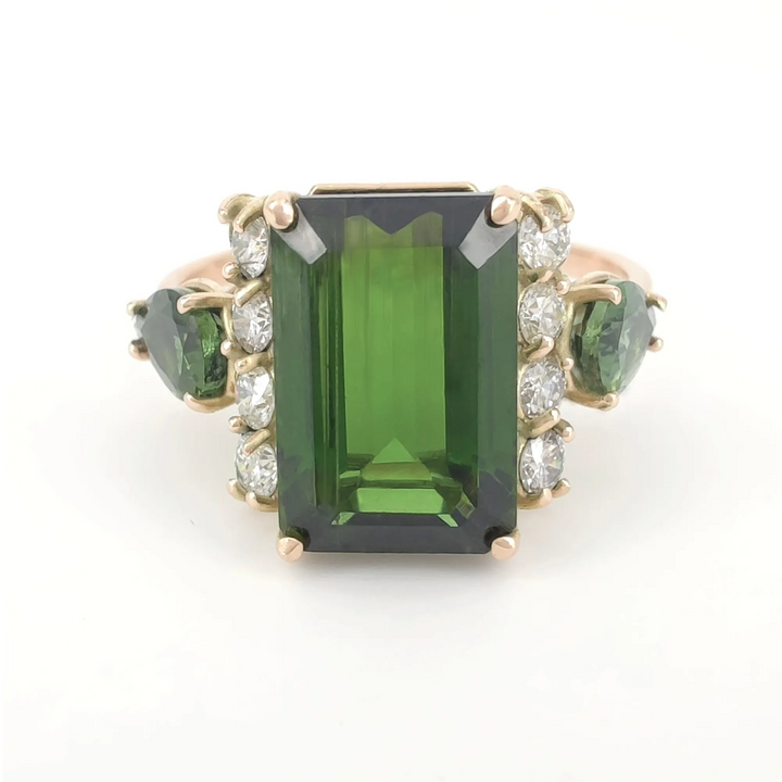 Left side view of a minimalist 14K yellow gold ring with an emerald-cut dark green tourmaline and diamond accents, highlighting the sleek and modern design