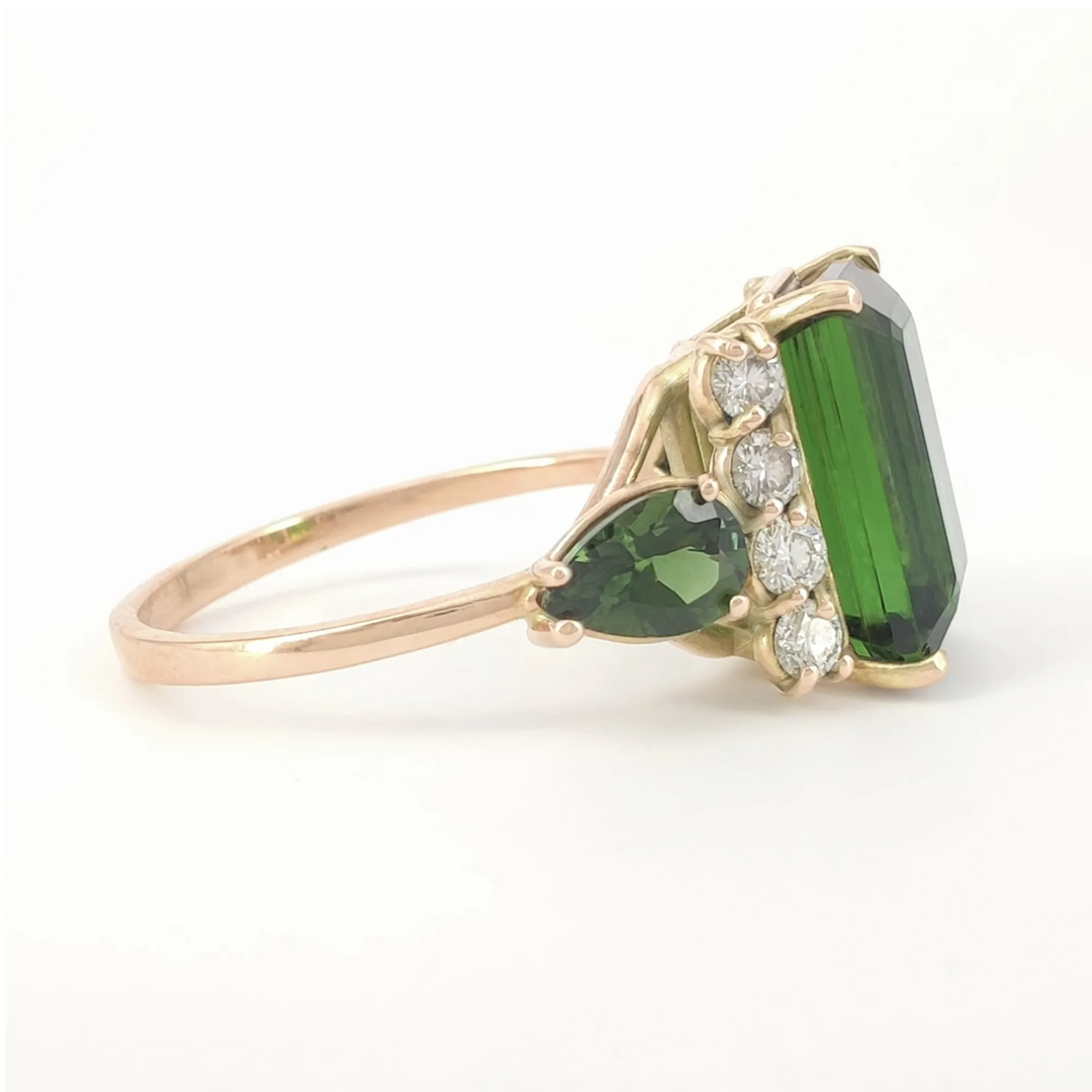 Right side view of a contemporary 14K yellow gold engagement ring with a dark green emerald-cut tourmaline and elegant diamond settings, perfect for a sophisticated proposal