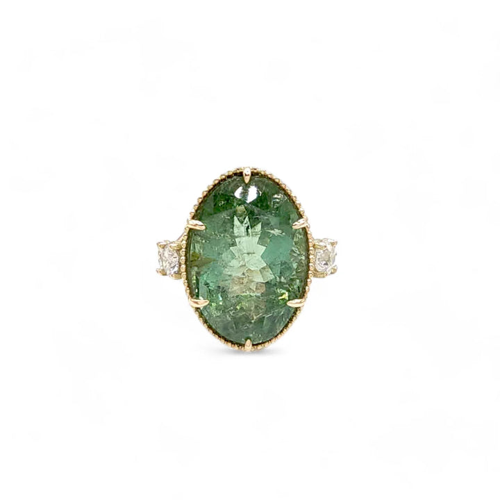 Front view of a 14K yellow gold cocktail ring featuring an oval green tourmaline with miligrain and diamonds, ideal for buyers looking for a sophisticated and modern jewelry piece