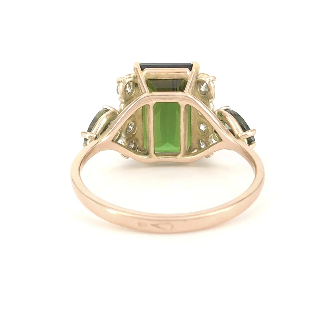 Back view of a 14K yellow gold engagement or cocktail ring featuring a central emerald-cut dark green tourmaline, surrounded by brilliant diamonds and pear-shaped green tourmalines, emphasizing the ring's fine details.