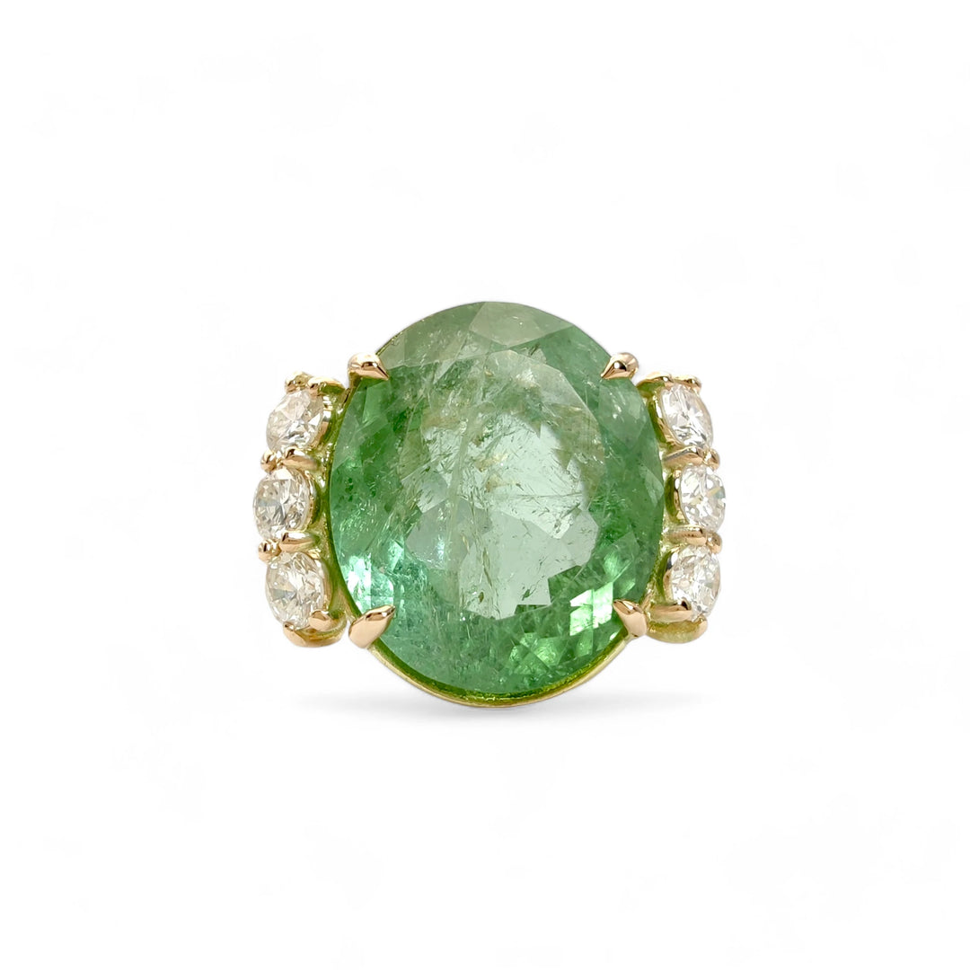 Front view of a 14K yellow gold engagement ring featuring a central oval green tourmaline and three diamonds on each side, perfect for buyers looking for a modern engagement ring