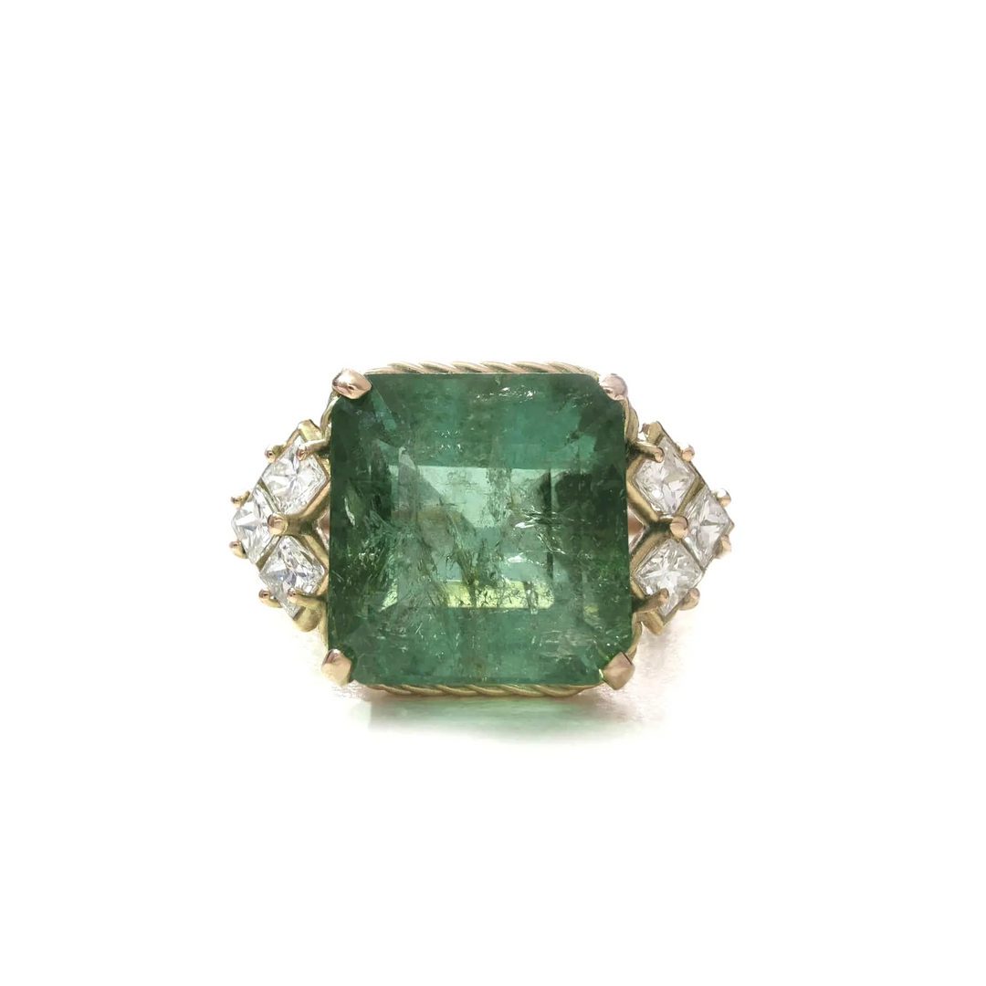 Front view of a vintage 14K yellow gold ring featuring a central green tourmaline flanked by princess-cut diamonds, perfect for those seeking a distinctive engagement ring