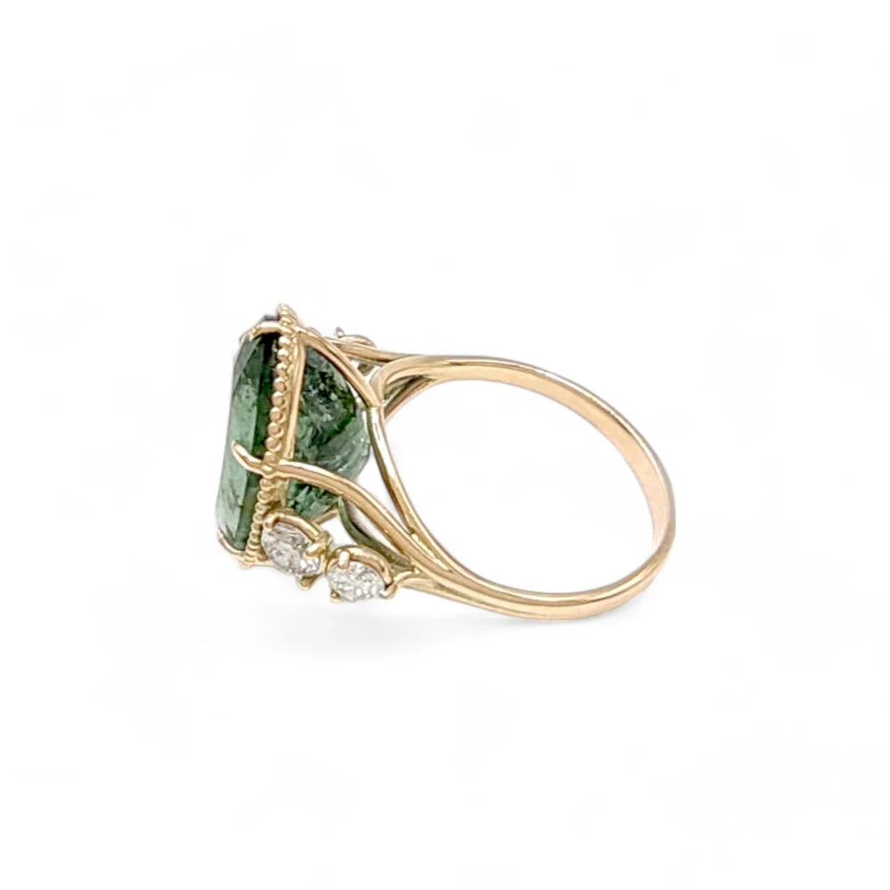 Left side view of a 14K yellow gold ring with a central oval green tourmaline and diamond accents, showcasing the ring's luxurious and detailed craftsmanship