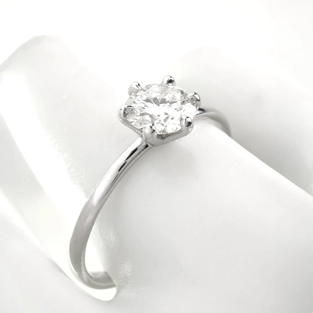 Close-up of solitaire diamond ring on finger, white gold setting
