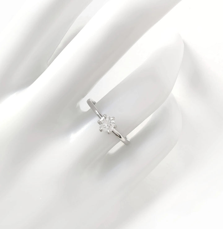Solitaire ring on white hand display – minimalist and timeless design