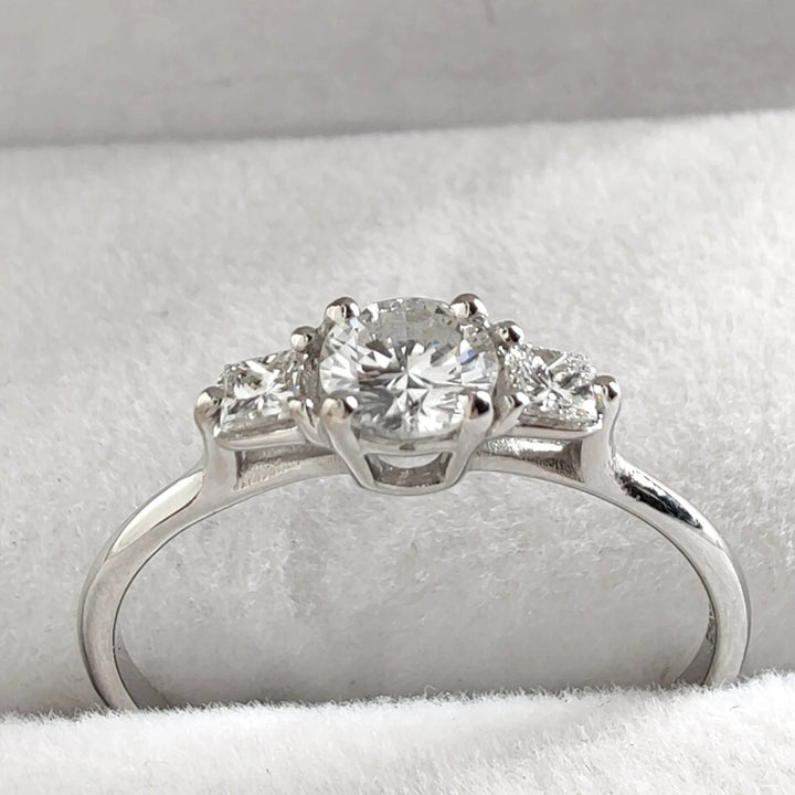 Elegant white gold ring featuring a large central diamond surrounded by smaller accent diamonds on either side. The sleek and modern design is perfect for everyday wear or special occasions
