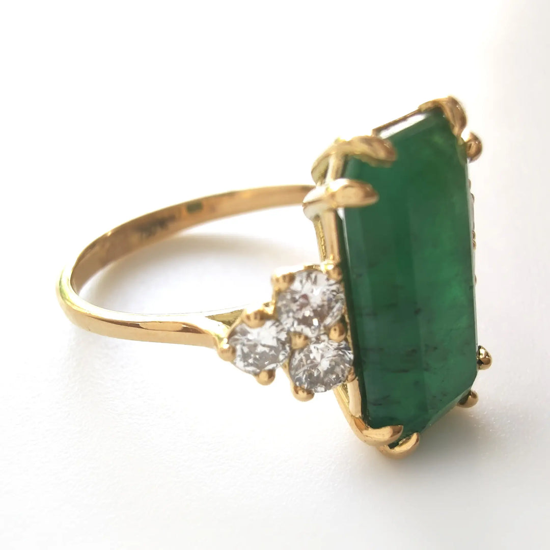 Right side view of a women’s 18K yellow gold engagement ring featuring an emerald and diamonds, perfect for Christmas gifts or proposals