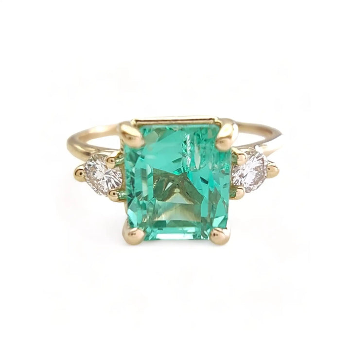 Front view of a 18K solid yellow gold engagement ring with an octagon-cut emerald and side diamonds