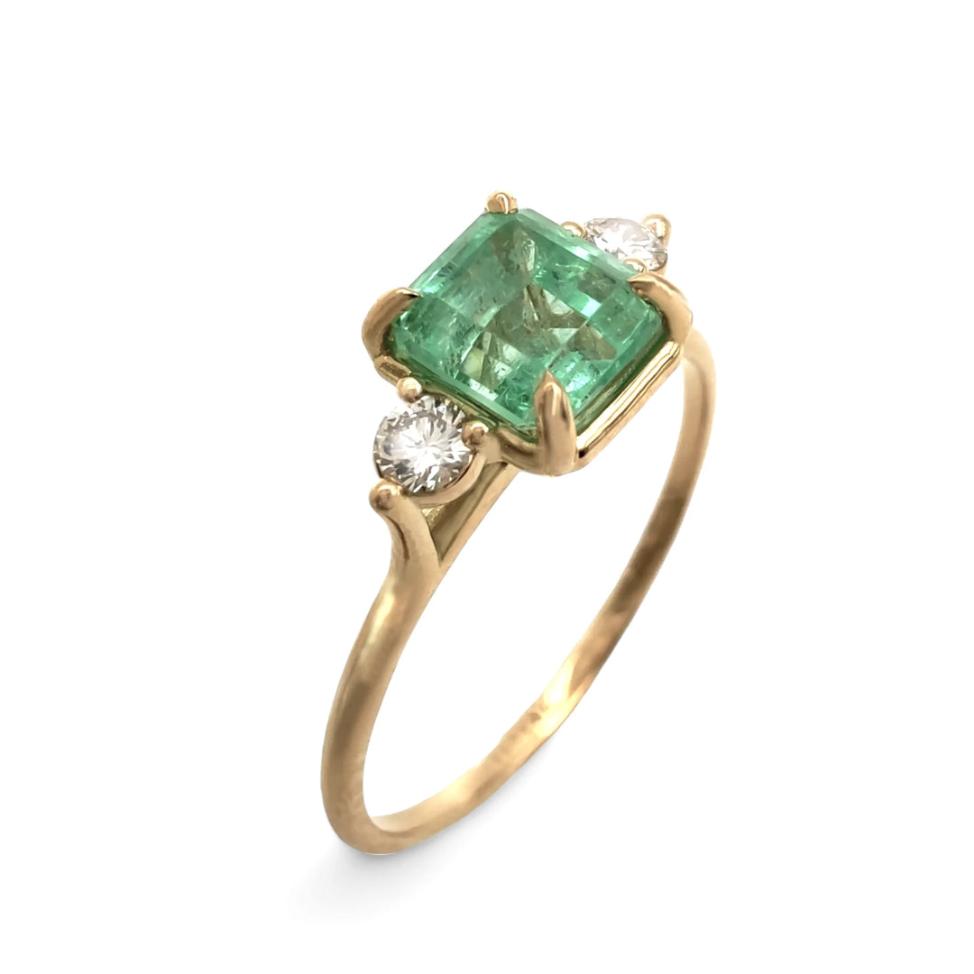 Discover this 18K gold emerald engagement ring with a three-stone design. Vertical rotated view highlights its elegance, perfect for proposals and special occasions