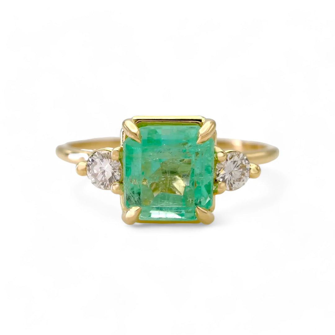 Front view of the 18K gold emerald engagement ring with diamonds. A classic three-stone engagement ring for women, handcrafted for timeless elegance