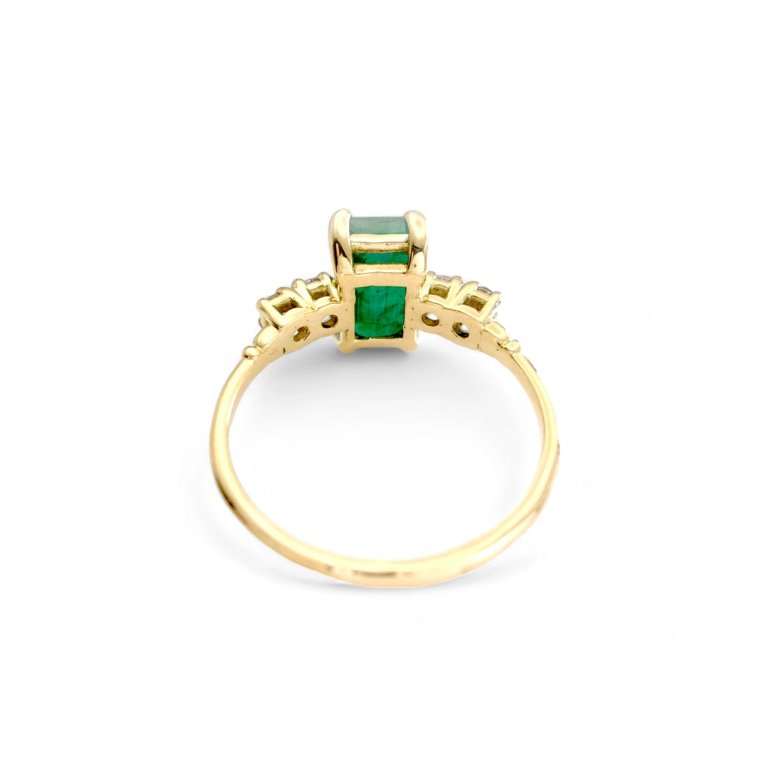 Back view of a classic 18K yellow gold engagement ring with a central emerald and brilliant diamonds in a timeless vintage design