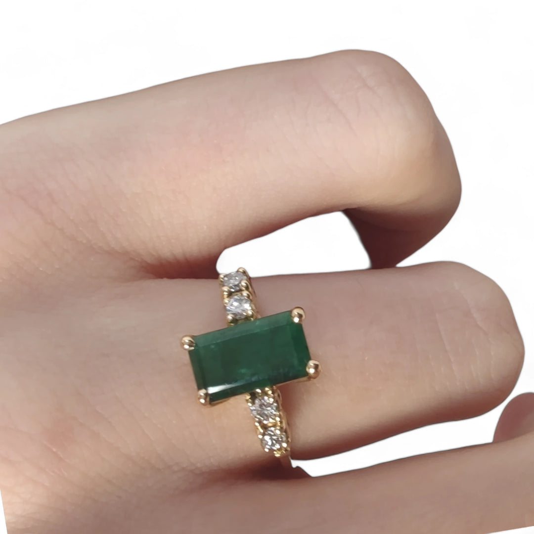 Elegant vintage-style emerald engagement ring in 18K yellow gold with diamonds, worn by a female model, ideal for proposals or Black Friday gifting