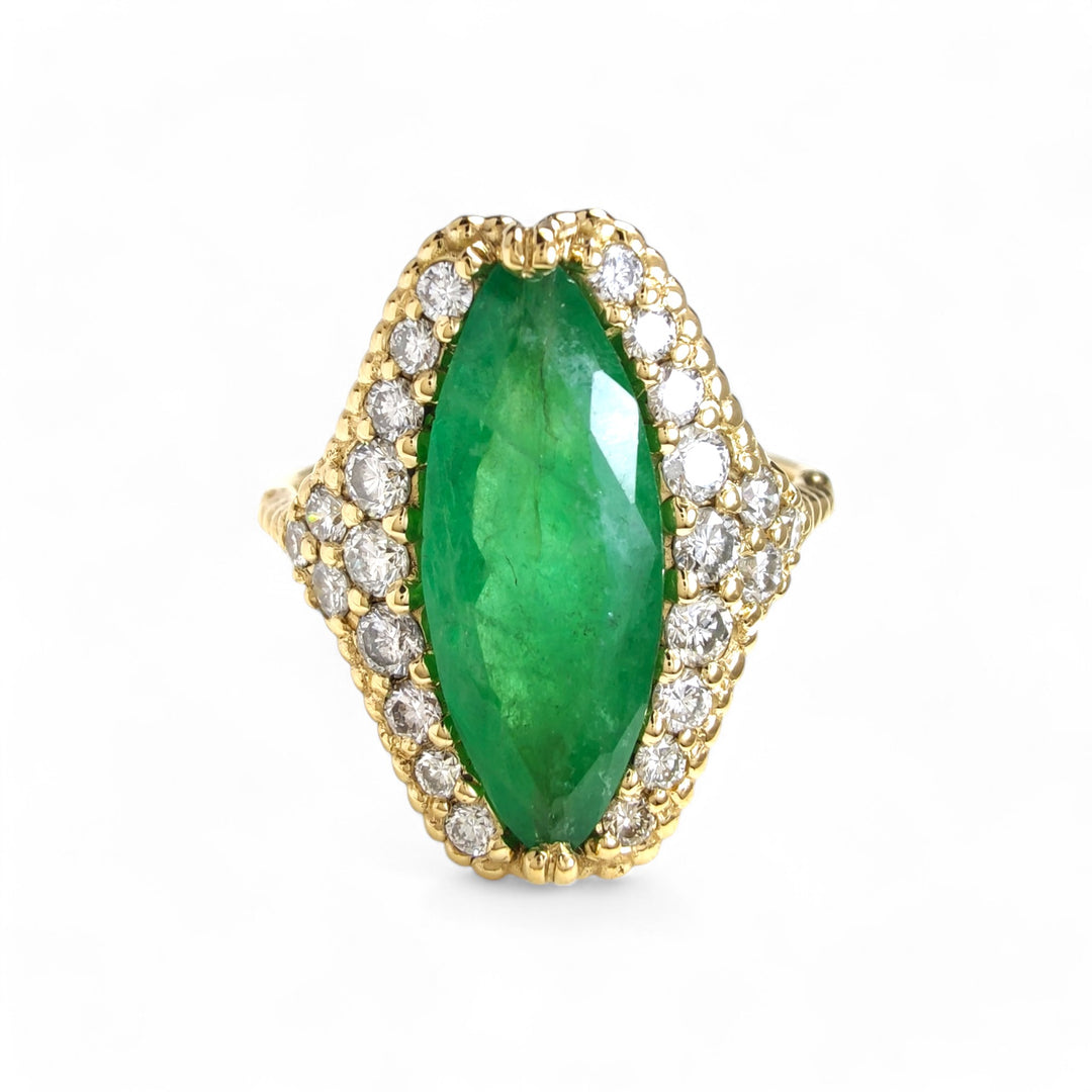 Front view of a handcrafted 18K yellow gold engagement ring featuring a central marquise emerald, diamond halo, and milgrain details