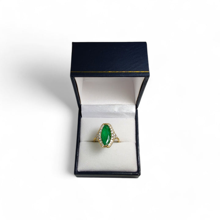 A spectacular 18K yellow gold marquise emerald ring with a diamond halo and milgrain details, displayed elegantly in a jewelry gift box, perfect for Christmas or proposals