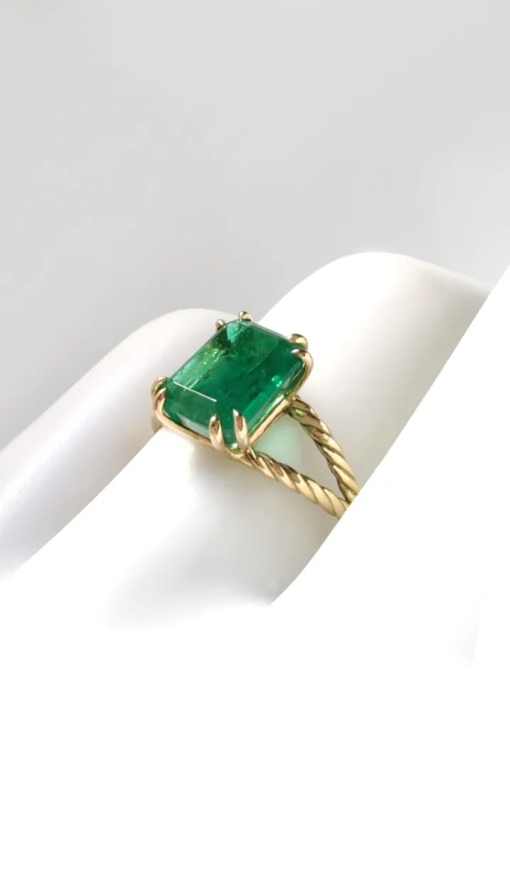 18K solid yellow gold women's ring, contemporary style, featuring a central emerald solitaire with double twisted shanks and prong setting. Perfect as a gift for women or an engagement ring