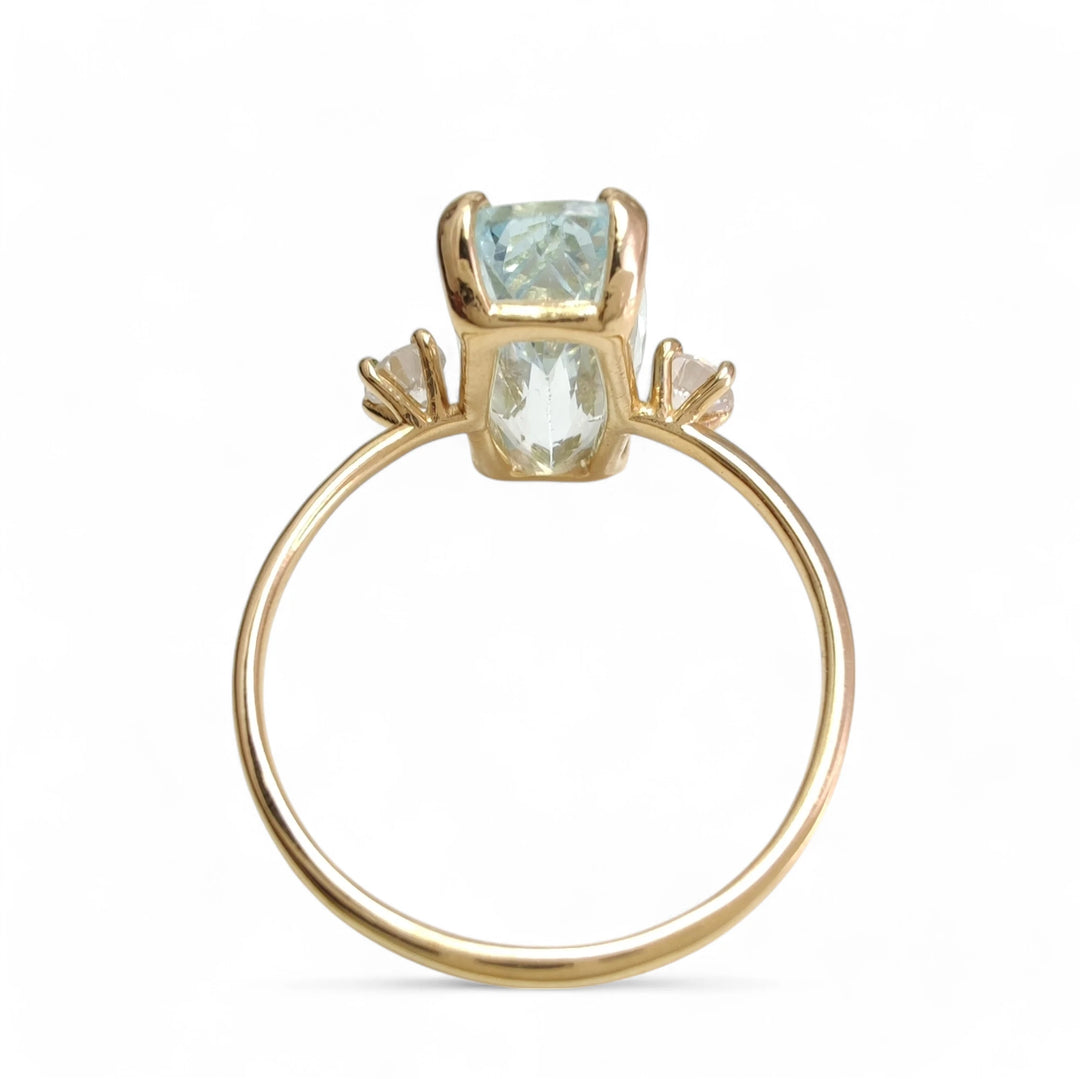 Engagement ring in 18K gold featuring aquamarine and diamonds, back view displayed on a white mannequin hand