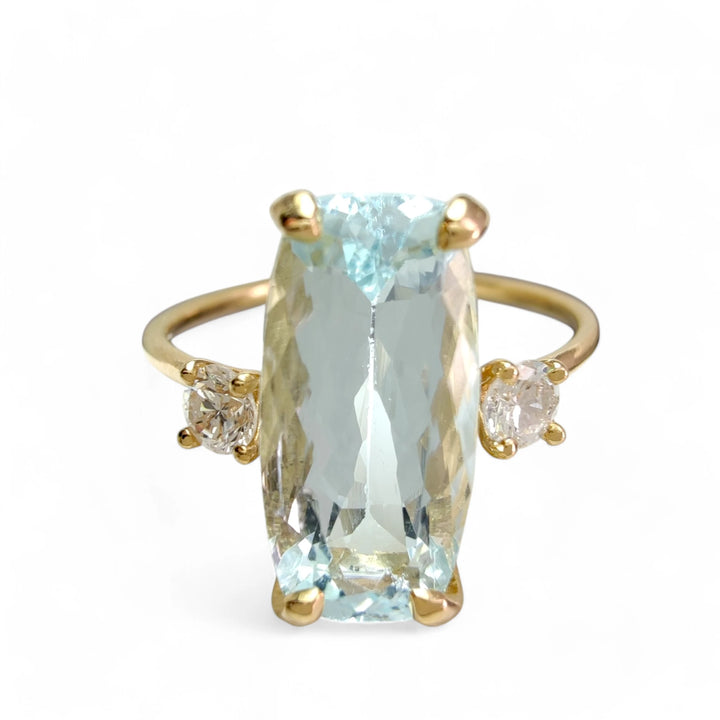 Engagement ring in 18K gold with aquamarine and diamonds, front view on a white mannequin hand