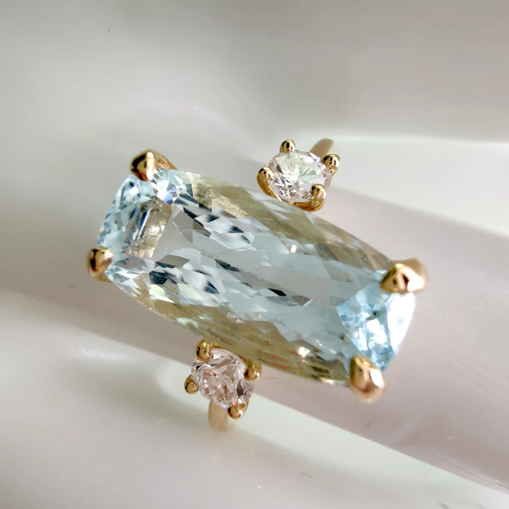  Engagement ring in 18K gold featuring aquamarine and diamonds, top view on a white mannequin hand