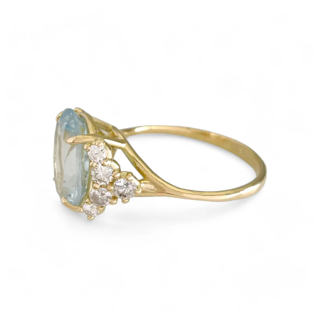 Left side view of an 18K yellow gold ring featuring a large oval aquamarine and diamond accents, displaying the ring’s elegant profile and craftsmanship.