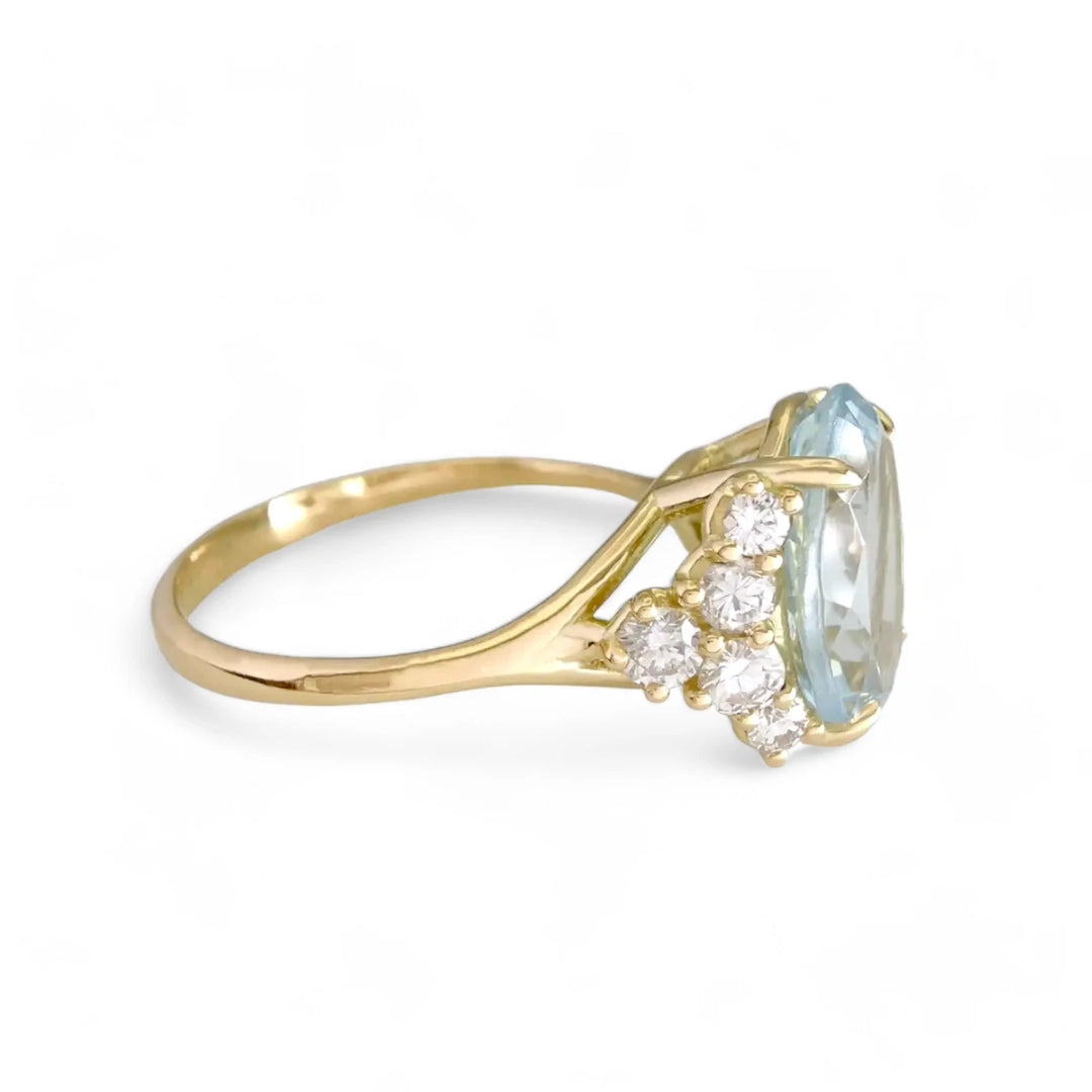 Right side view of a genuine oval aquamarine engagement ring in 18K yellow gold, adorned with brilliant diamonds, highlighting its luxurious design.