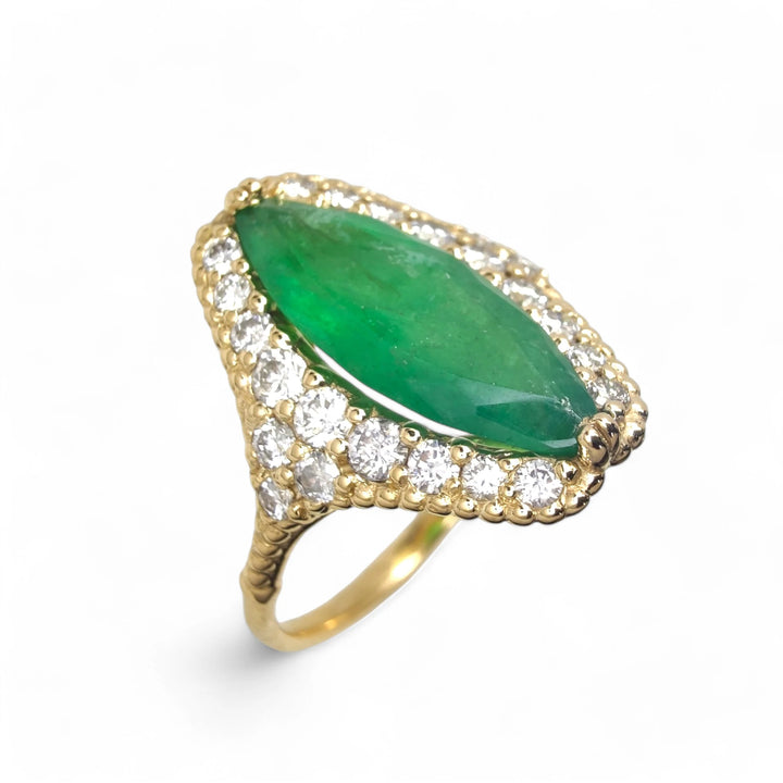 Top perspective view of an exclusive 18K yellow gold ring featuring a central marquise emerald surrounded by a diamond halo, with a milgrain band ending in a unique V design