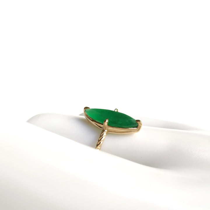 Horizontal side view of a women’s solitaire ring with a marquise emerald and vintage band crafted in 18K yellow gold displayed on a mannequin hand