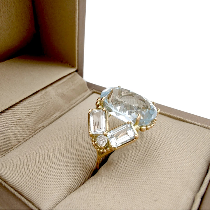 Vintage-inspired cocktail ring with an oval aquamarine and diamond accents in 14K yellow gold, displayed elegantly in a jewelry gift box