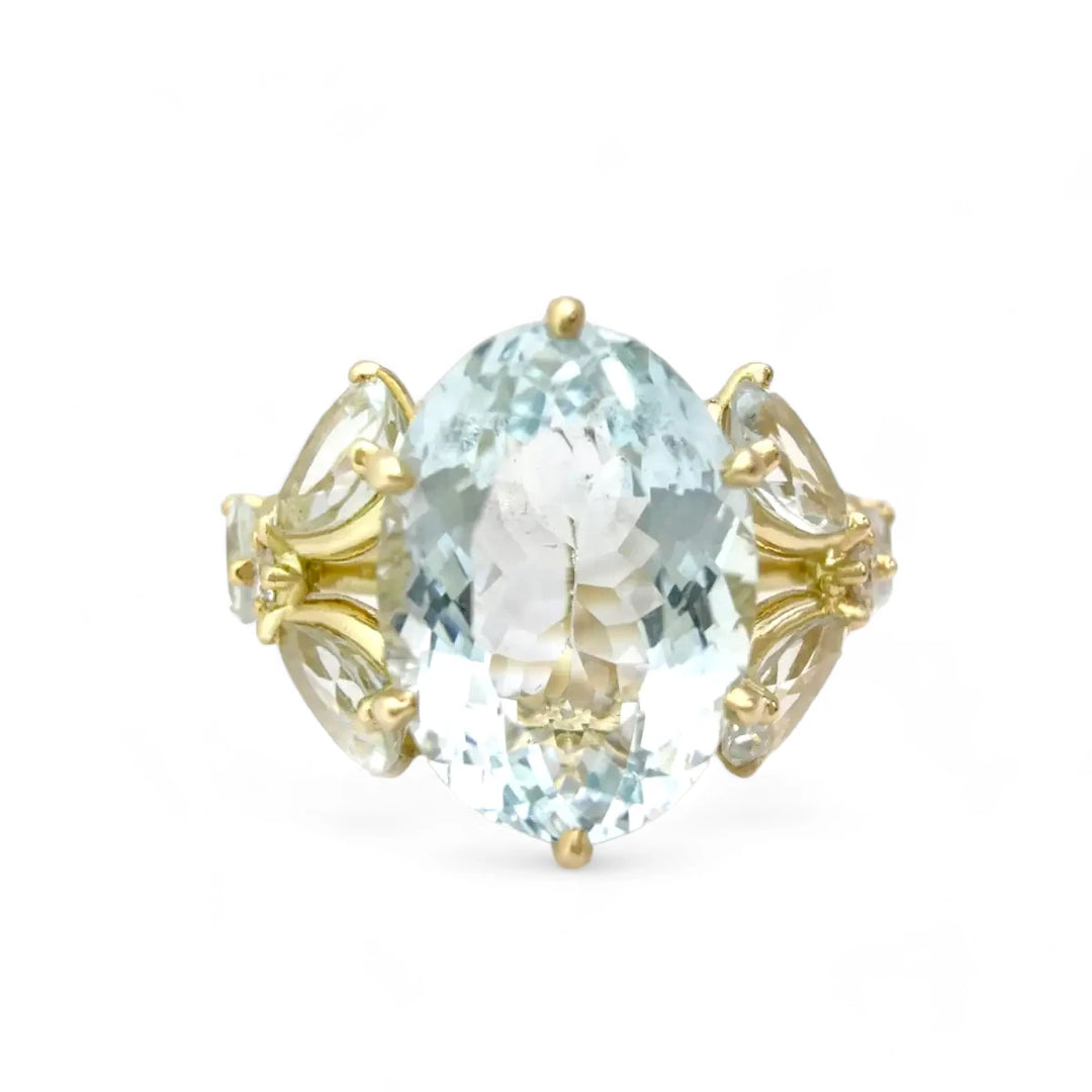 Front view of an elegant women’s ring with an oval aquamarine centerpiece, marquise aquamarines, and diamond accents, perfect for engagements or cocktail events