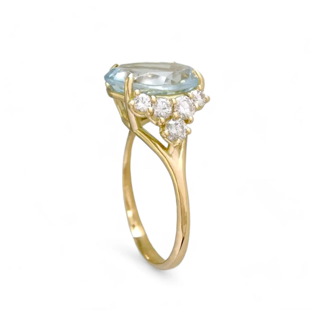 Vertical perspective view of a new 18K yellow gold engagement ring featuring a large, genuine oval aquamarine and five brilliant-cut diamonds on each side, perfect for Christmas or Black Friday gifts.