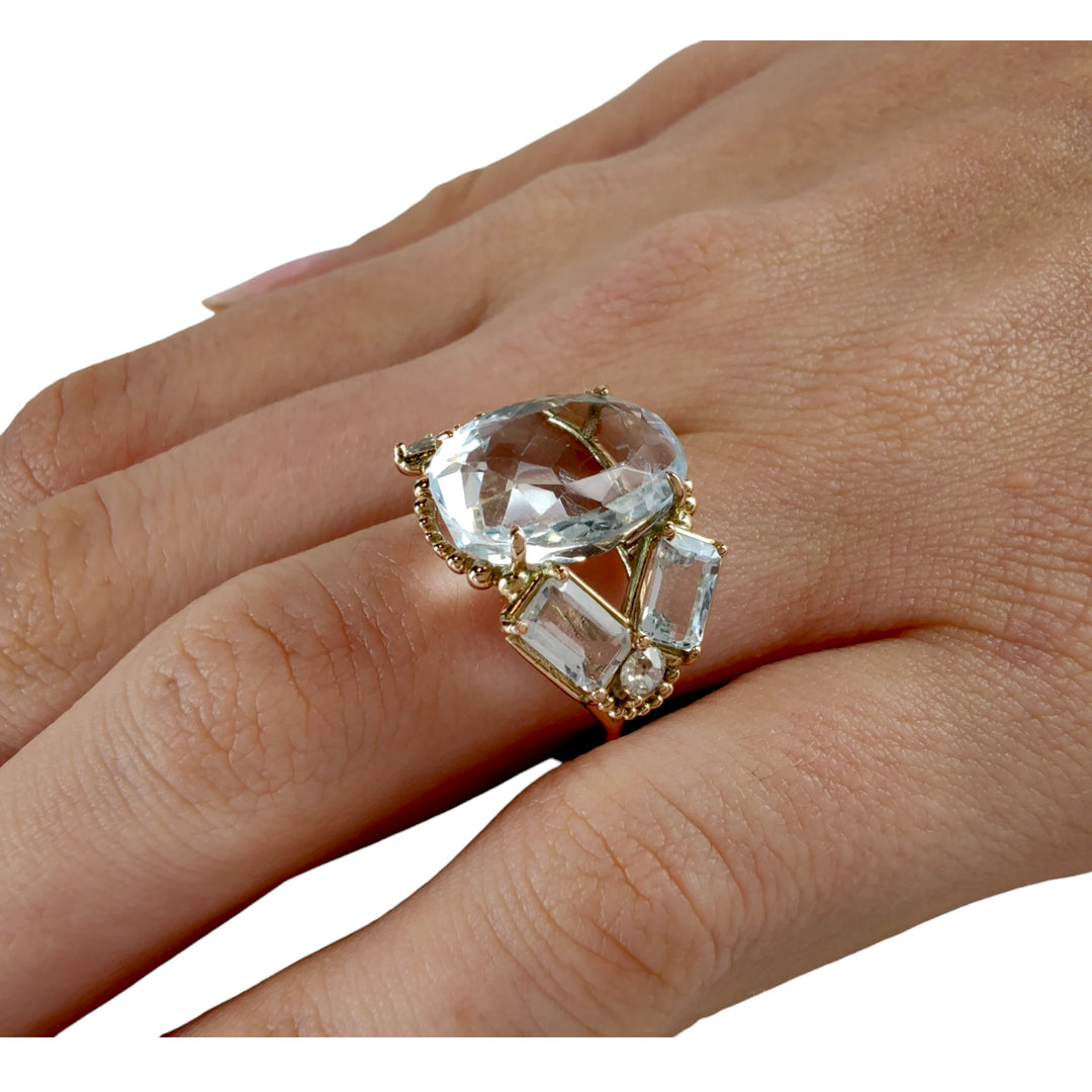 Bold and artistic 14K yellow gold ring with aquamarines and diamonds worn on a model’s hand, showcasing pose 3