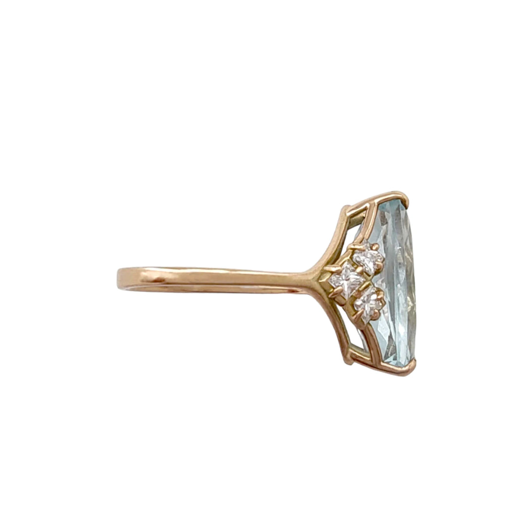 Right side view of a unique 14K yellow gold ring with a rectangular aquamarine centerpiece and diamond detailing in a V formation