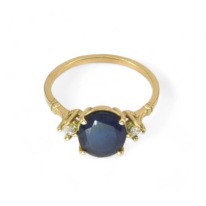 Front view of a vintage-inspired 18K yellow gold three-stone ring featuring an oval sapphire centerpiece and diamonds, perfect for women