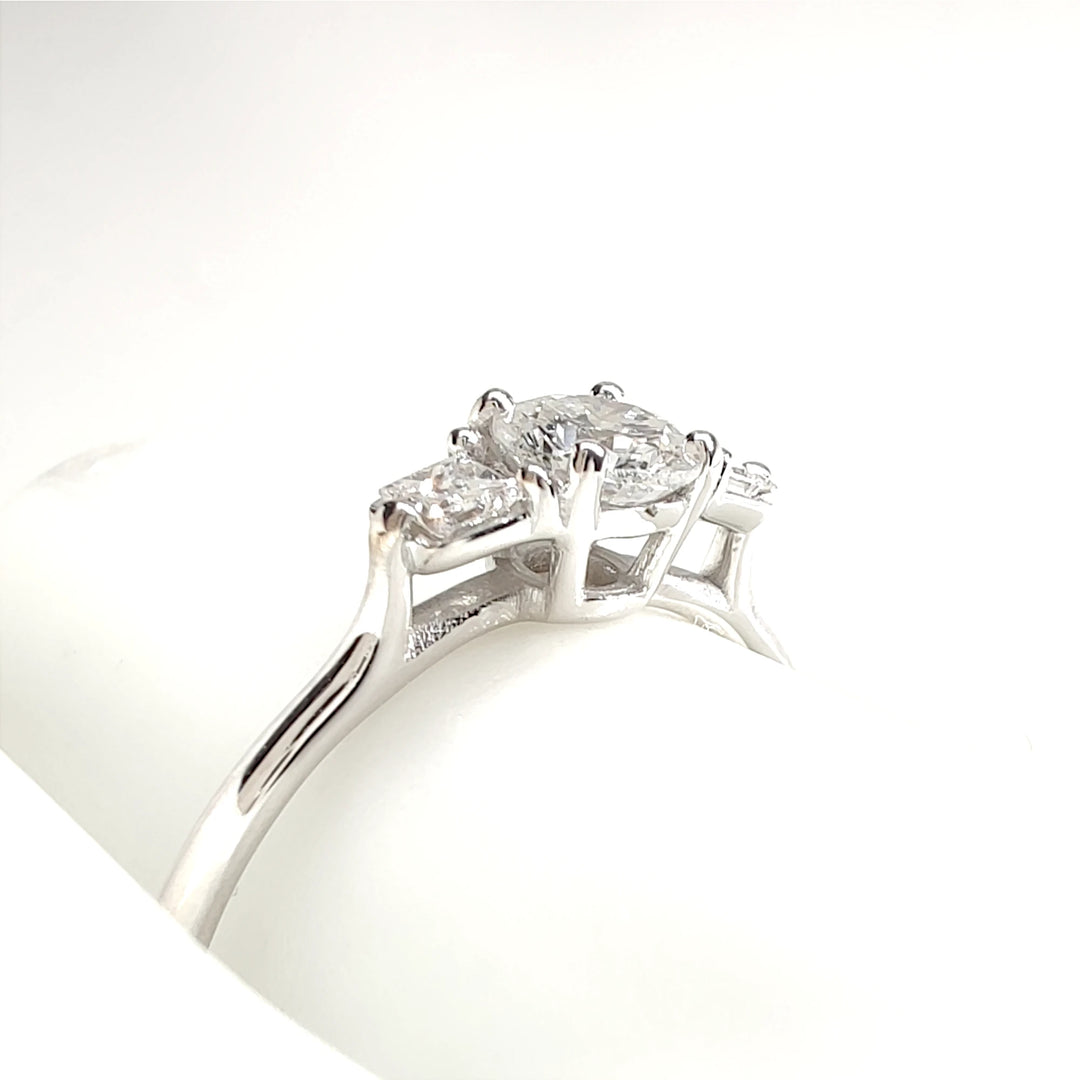 Stylish white gold ring featuring a large central diamond flanked by two smaller diamonds on each side. The sleek and modern design makes it a versatile choice for everyday wear or special events