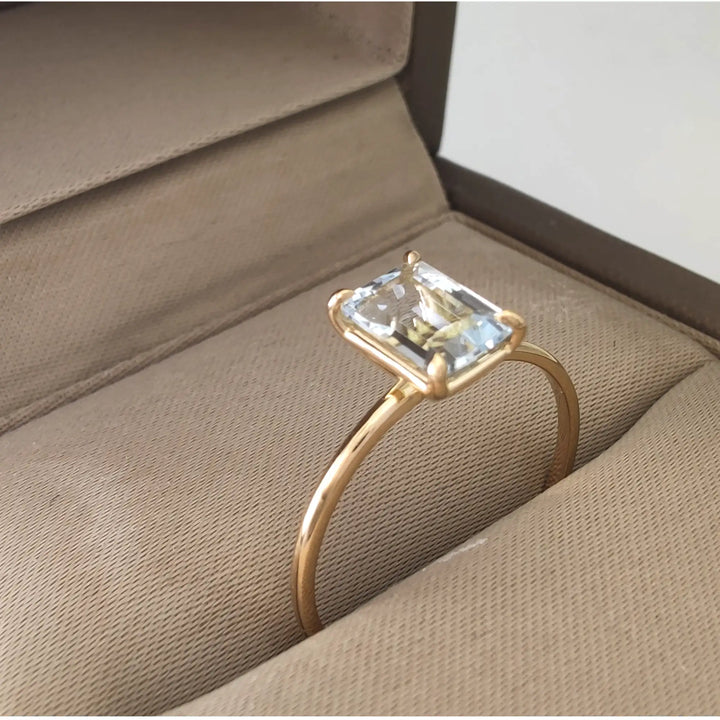  Elegant solitaire aquamarine ring in 18K yellow gold displayed in a jewelry box