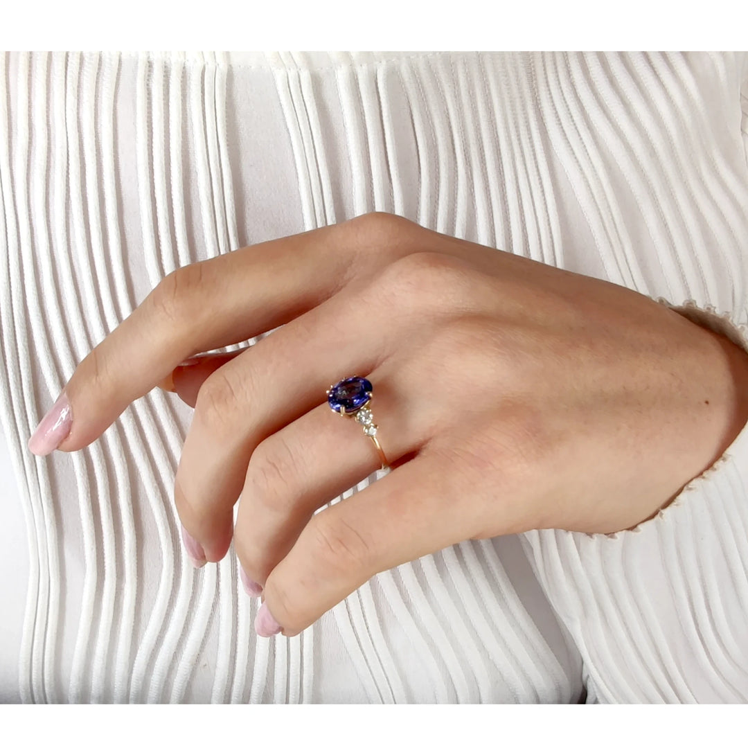 Elegant Tanzanite ring in 14K gold with diamonds, shown on a woman’s hand with body pose