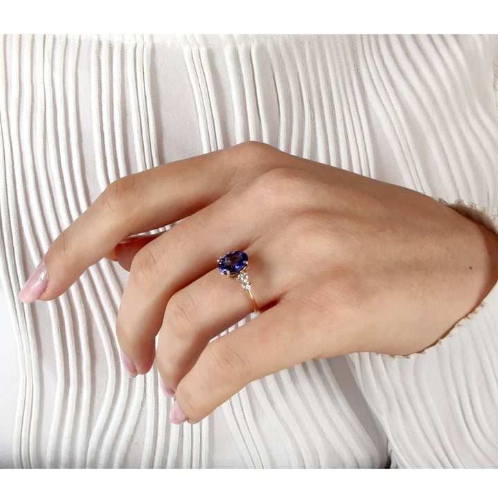 Elegant Tanzanite ring in 14K gold with diamonds, shown on a woman’s hand with body pose