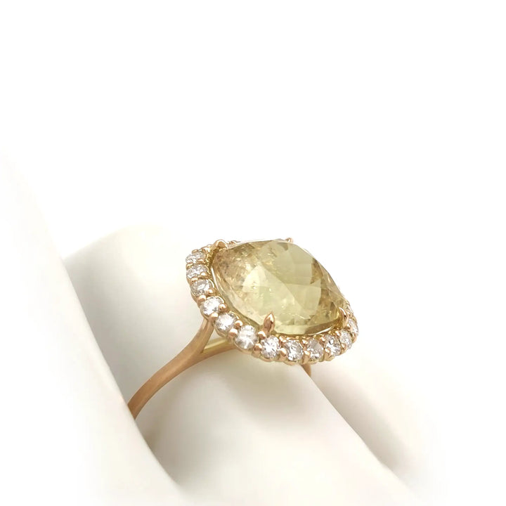 Elegant 14K yellow gold ring featuring a yellow Tourmaline surrounded by a diamond halo displayed on a white mannequin hand