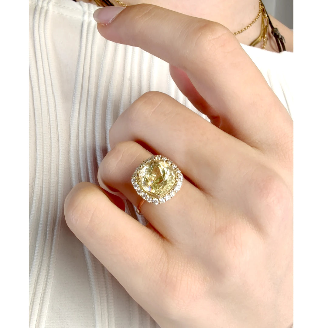 Stunning yellow Tourmaline engagement ring with a diamond halo crafted in 14K solid yellow gold worn on a woman’s hand